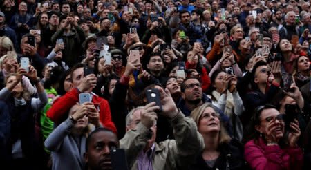 FILE PHOTO - Tourists use their mobile phones to take pictures at the Old Town Square in Prague, Czech Republic September 25, 2017.  REUTERS/David W Cerny