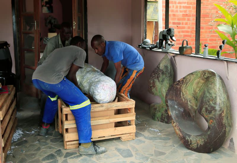 Zimbabwean sculptor Dominic Benhura is assisted by fellow artists packing a finished piece for export, at his studio in Harare