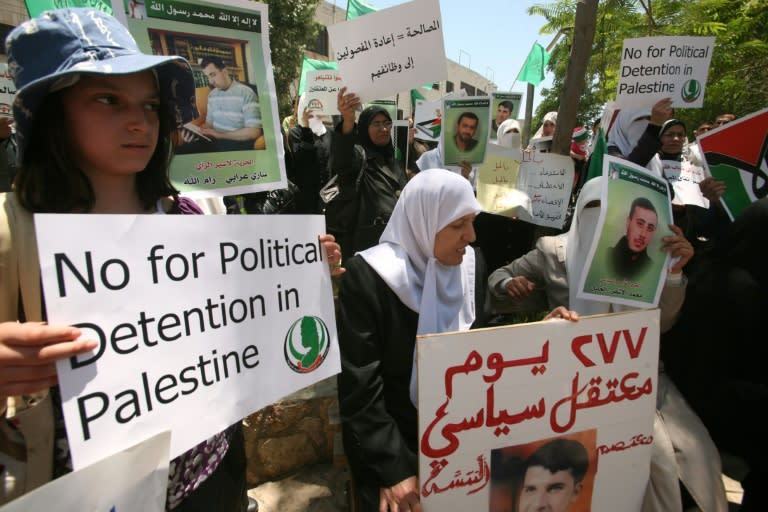 Hamas supporters hold up pictures of relatives they say were arrested and imprisoned for political reasons by PA security forces, in the West Bank city of Hebron on June 9, 2011