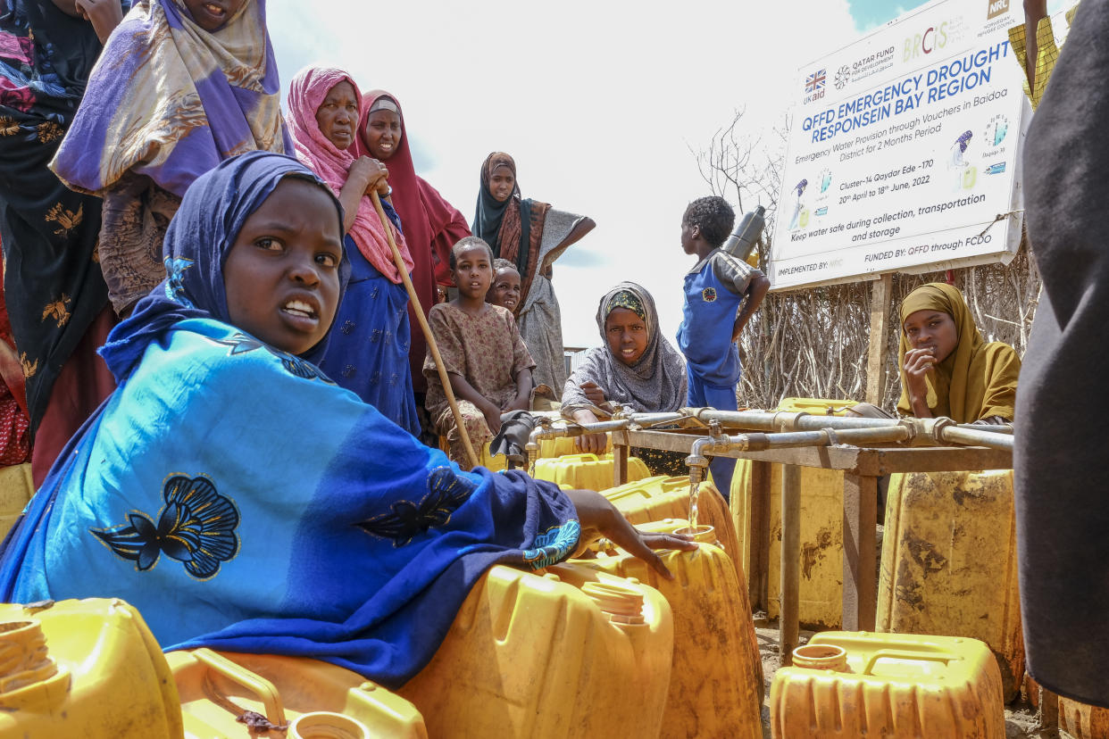 Isha Kerow, left, and other Somalis displaced by drought fill jerrycans with water distributed by the Norwegian Refugee Council, on the outskirts of Baidoa, in Somalia Saturday, Oct. 29, 2022. Ships loaded with grain departed Ukraine on Tuesday, Nov. 1, 2022 despite Russia suspending its participation in a U.N.-brokered deal that ensures safe wartime passage of critical food supplies meant for parts of the world struggling with hunger such as Somalia. (AP Photo/Mohamed Sheikh Nor)