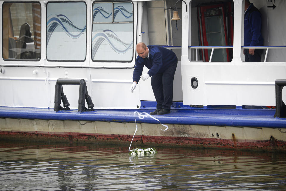 A wreath is lowered in the Danube during a memorial ceremony for the victims, one year after the Mermaid boat accident, in Budapest, Hungary, Friday, May 29, 2020. Commemorations are taking place on the one year anniversary of the Danube River tragedy in which a sightseeing boat carrying mostly tourists from South Korea sank after a collision with a river cruise ship that killed at least 27 people. (AP Photo/Laszlo Balogh)