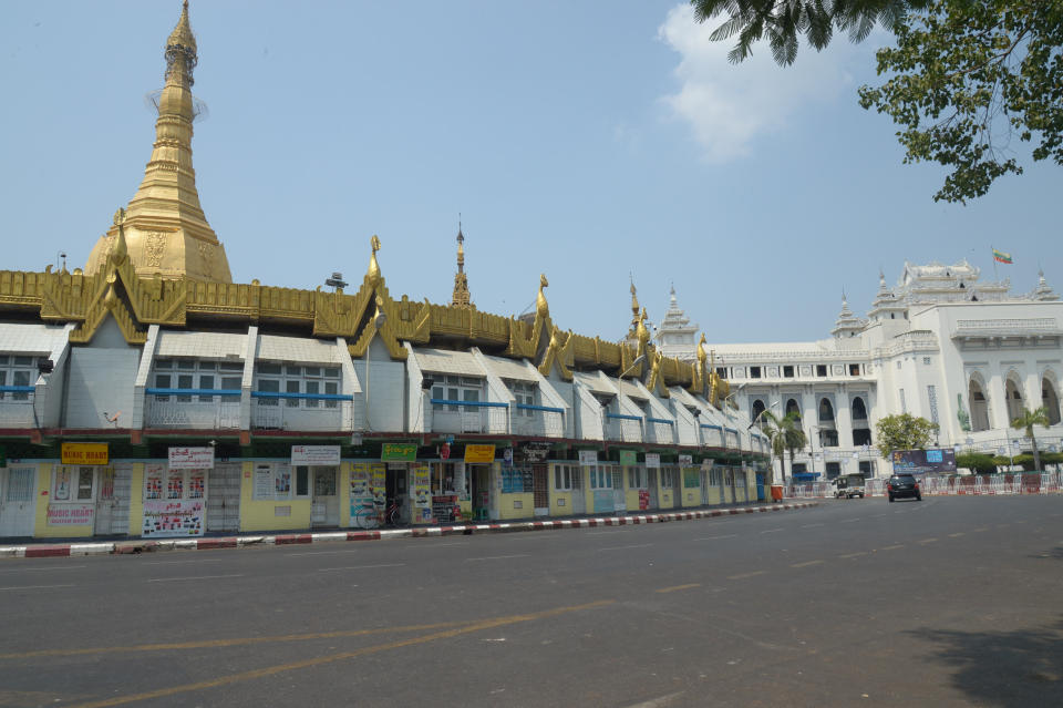 A vehicle drives along an empty road around the Sule Pagoda in Yangon, Myanmar, Wednesday, March 24, 2021. Anti-coup protesters on Wednesday tried a new tactic that they dubbed a 'silence' strike, calling for people to stay home and businesses to close for the day. (AP Photo)