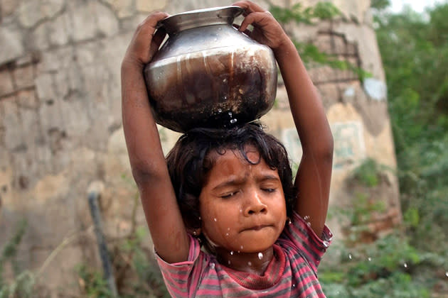 Five-year-old Joshiya carries a metal pitcher filled with water from a near-by well at Badarganj village in the western Indian state of Gujarat August 5, 2012. Armed with the latest monsoon rainfall data, weather experts finally conceded this month that India is facing a drought, confirming what millions of livestock farmers around the country had known for weeks. Picture taken August 5, 2012. To match feature INDIA-DROUGHT/ REUTERS/Ahmad Masood