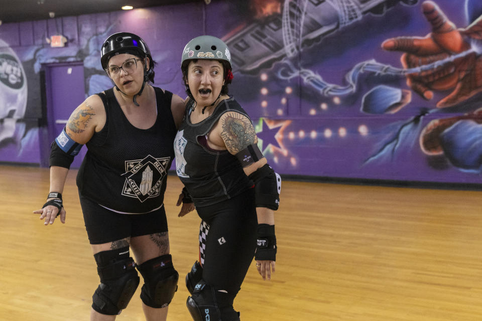 Amanda "Curly Fry" Urena, right, pratices blocking, Tuesday, March 19, 2023, at United Skates of America in Seaford, N.Y. (AP Photo/Jeenah Moon)