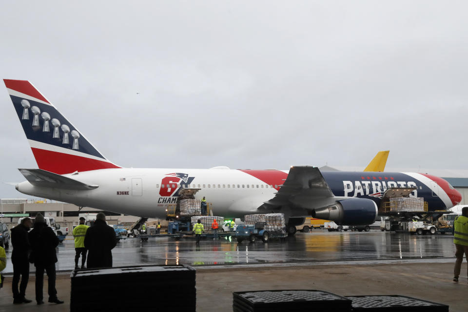 Palettes of N95 respirator masks are off-loaded from the New England Patriots football team's customized Boeing 767 jet on the tarmac, Thursday, April 2, 2020, at Logan Airport, in Boston, after returning from China. The Kraft family deployed the Patriots team plane to China to fetch more than one million masks for use by front-line health care workers to prevent the spread of the coronavirus. (AP Photo/Elise Amendola)