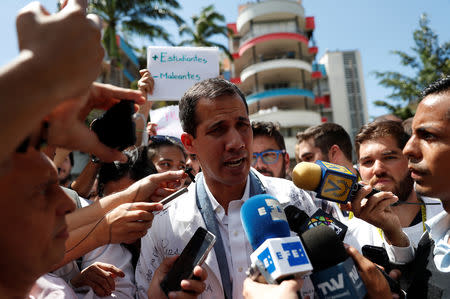 Venezuelan opposition leader and self-proclaimed interim president Juan Guaido speaks to the media during a protest against Venezuelan President Nicolas Maduro's government in Caracas, Venezuela January 30, 2019. REUTERS/Carlos Garcia Rawlins