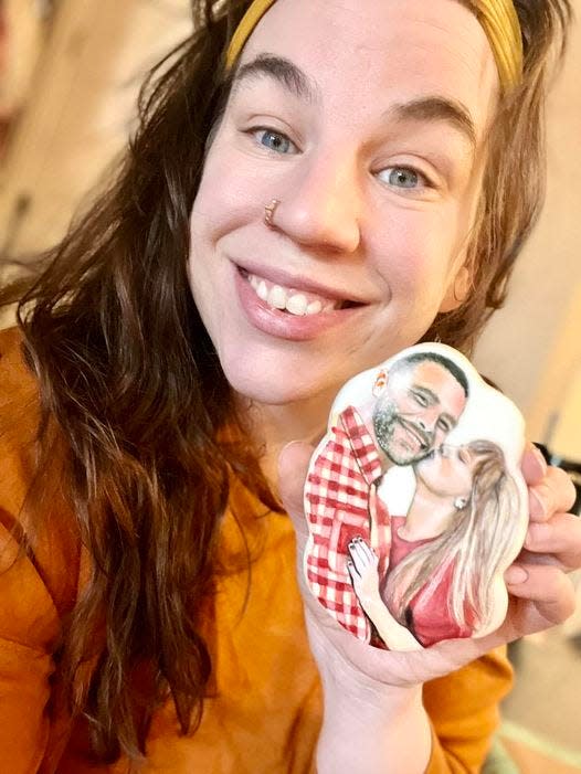 Justina Rucinski poses with one of the cookies from her Taylor Swift-Travis Kelce set. This cookie took her more than four hours to complete.