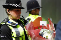 <p>A police officer carries a bunch of flowers with a note near Borough Market in London, June 4, 2017. (Photo: Peter Nicholls/Reuters) </p>