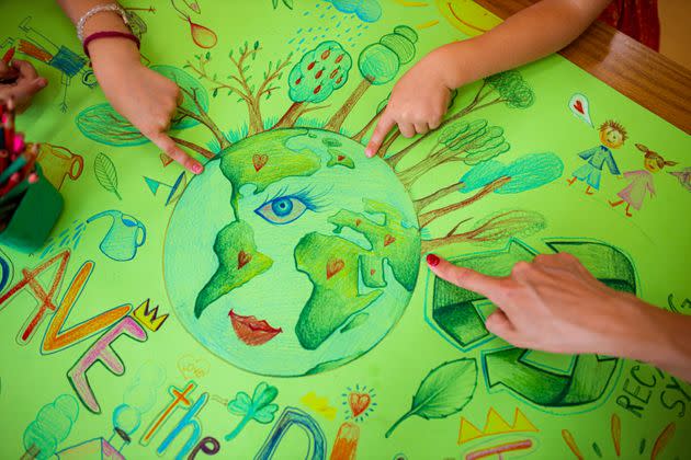 Caring female preschool teacher together with her female student, drawing the poster for the Eart Day, trying to outreach community to SAve the planet, and also to learn child from the young age about responsibility for the good of Earth (Photo: Dusan Stankovic via Getty Images)