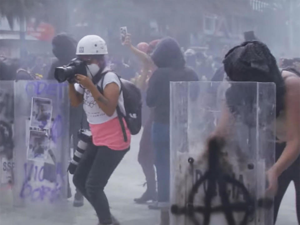 News photographer Sáshenka Gutiérrez at work in a conflict zone, as police clash with demonstrators protesting against violence toward women in Mexico, in the new documentary 