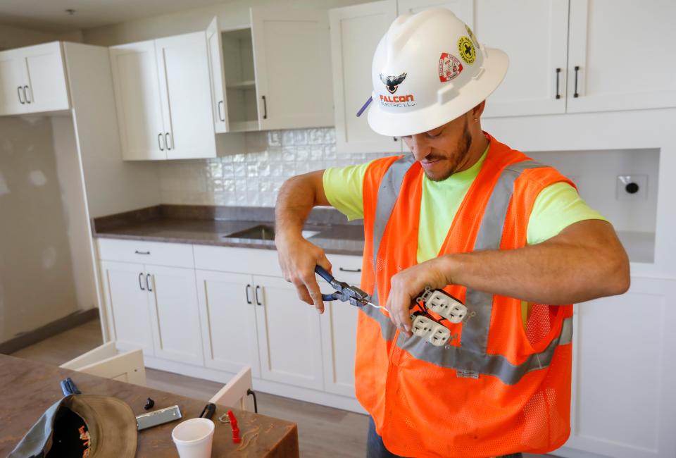 Corey Binney, an electrical apprentice from the Kestrel Apprenticeship Training Center, installs an outlet at The Montclair on Wednesday, April 6, 2022.