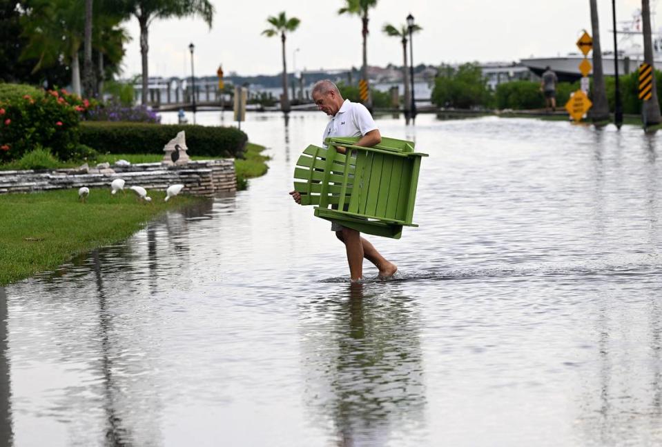 Arnie Moshier moves furniture from his dock on Riverview Boulevard as Hurricane Idalia approached on August 29, 2023.