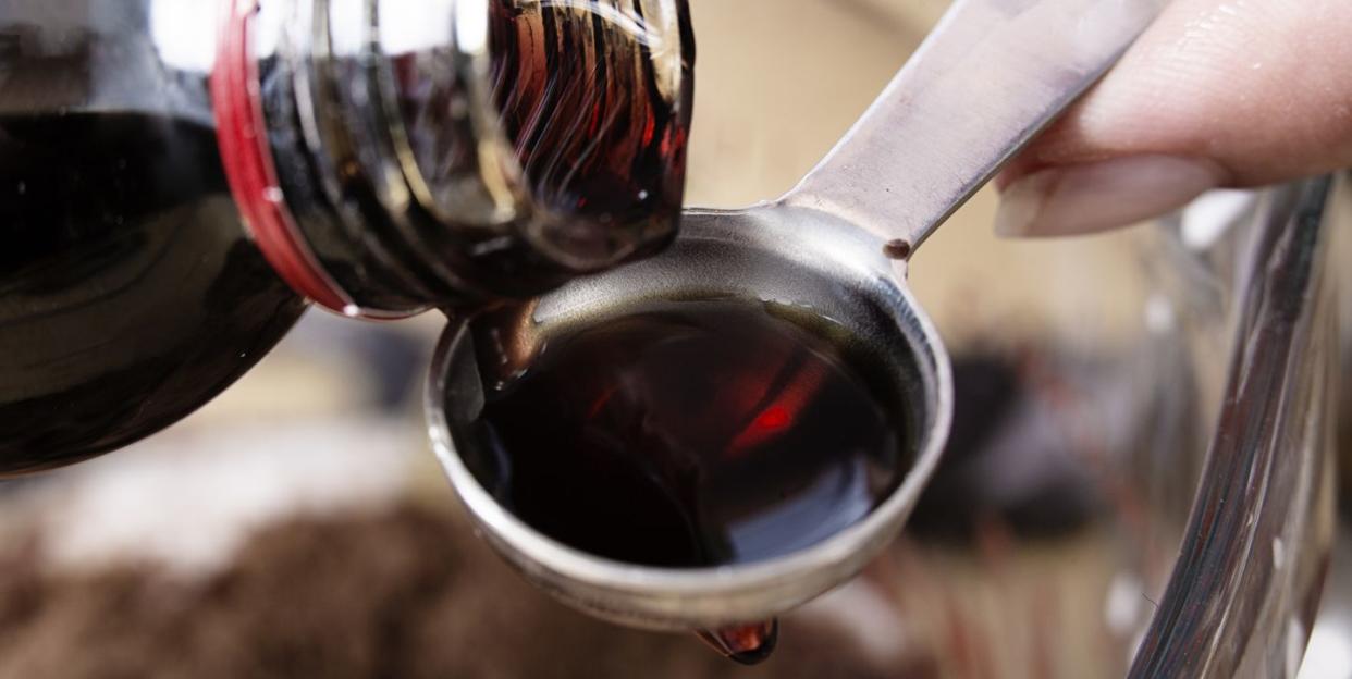 close up of medicine being poured onto a teaspoon