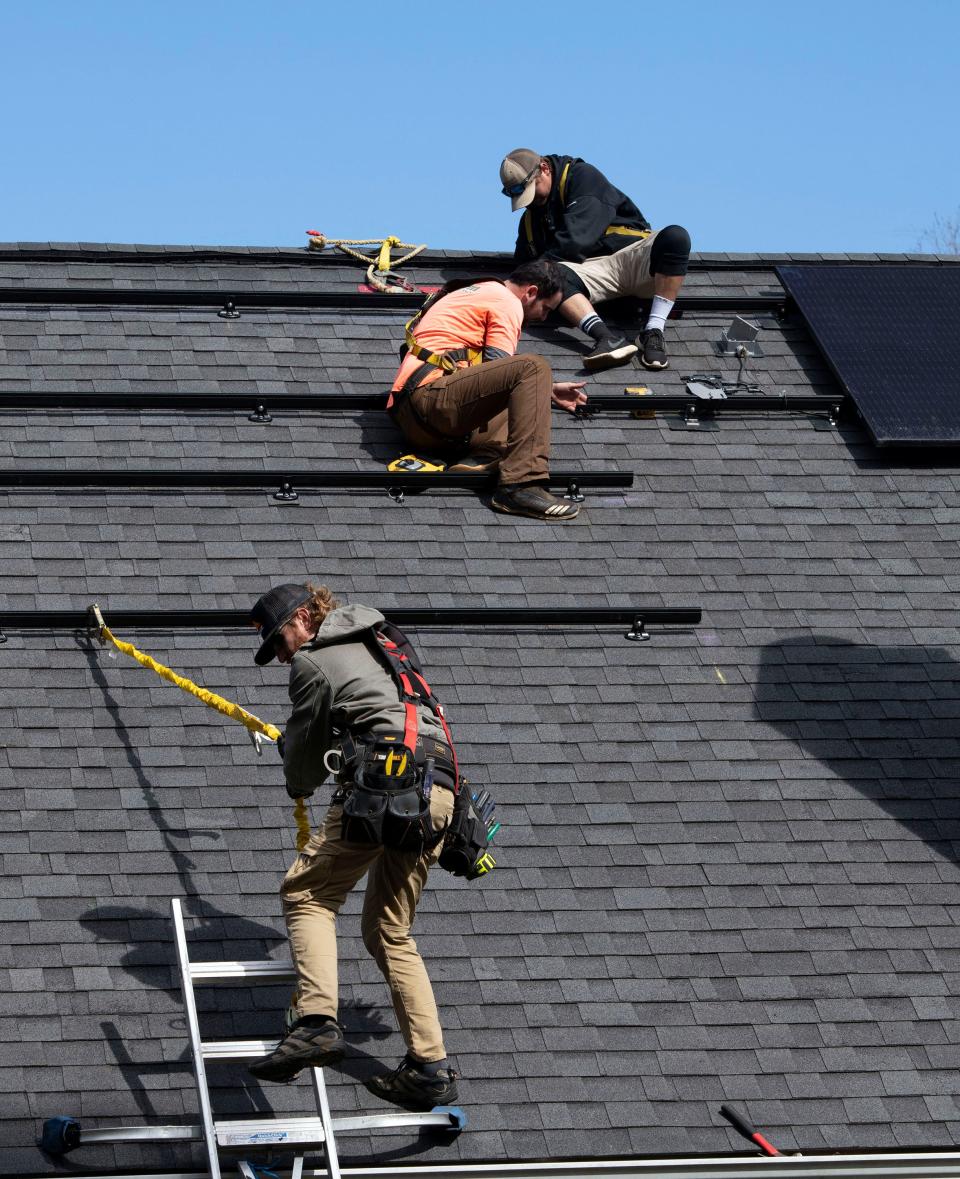 Sun Farm Energy workers prepare to install solar panels on a home in Escambia County on Feb. 8.