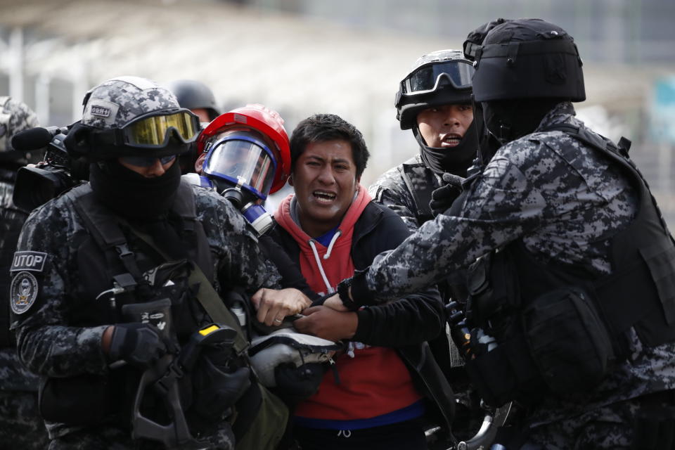 A supporter of former President Evo Morales is detained during clashes with police, in La Paz, Bolivia, Friday, Nov. 15, 2019. Bolivia's new interim president Jeanine Anez faces the challenge of stabilizing the nation and organizing national elections within three months at a time of political disputes that pushed Morales to fly off to self-exile in Mexico after 14 years in power. (AP Photo/Natacha Pisarenko)