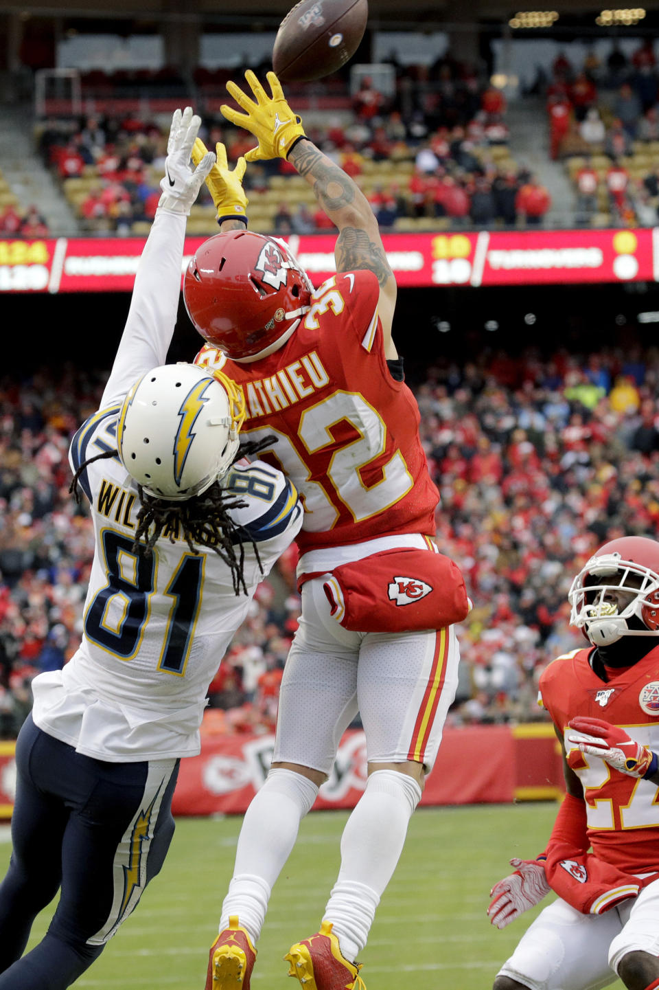 Kansas City Chiefs safety Tyrann Mathieu (32) intercepts a pass intended for Los Angeles Chargers wide receiver Mike Williams (81), as cornerback Rashad Fenton (27) watches, during the first half of an NFL football game in Kansas City, Mo., Sunday, Dec. 29, 2019. (AP Photo/Charlie Riedel)