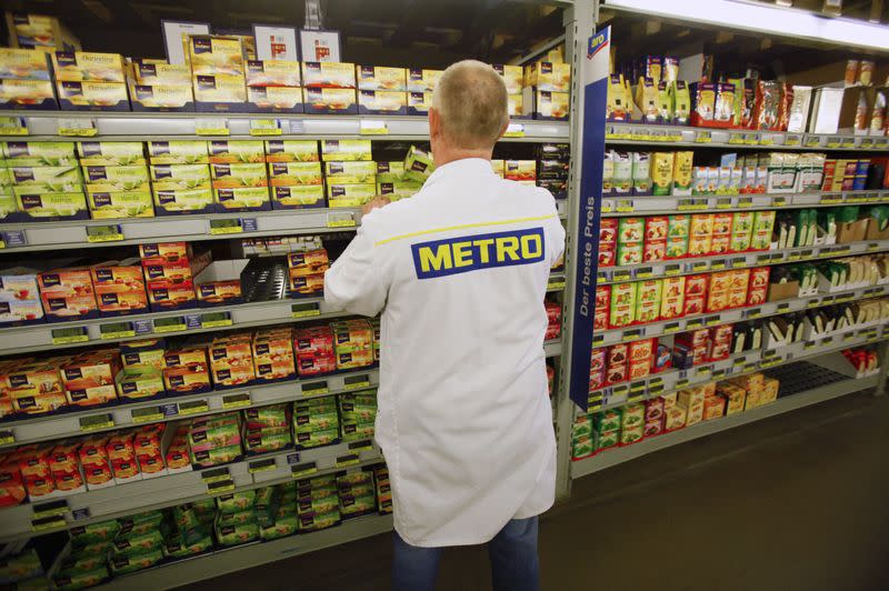 An employee of a cash and carry markets of Metro AG places a box of tea on the shelves in one of Germany's top three Metro markets in Sankt Augustin