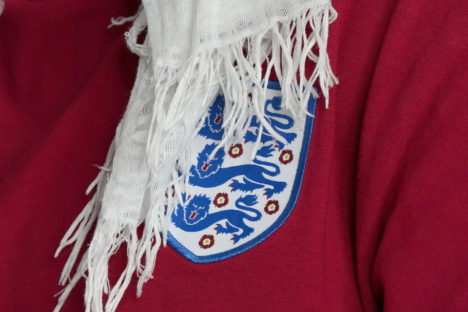 The three lions emblem on the shirt worn by Huda Jawad, during an interview with The Associated Press, at her home in London, Friday, Aug. 18, 2023. Jawad is a member of a fan group known as the Three Hijabis for their traditional Muslim headscarves, a group that campaigns against discrimination in football. (AP Photo/Frank Augstein)