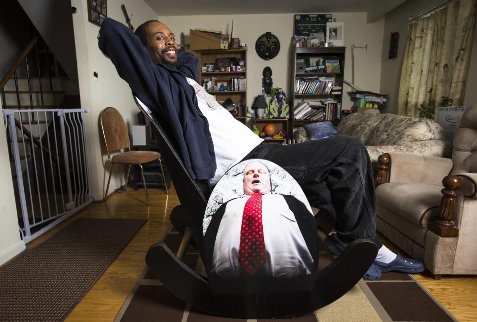 Nuwame, poses on his "Mayor Rob Ford Crack Rocker", a rocking chair made completely of cardboard in Mississauga