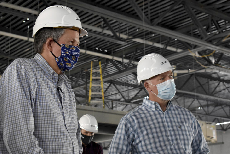 Republicans U.S. Sen. Steve Daines, left, and Rep. Greg Gianforte are seen touring a technology company facility under construction on Wednesday, Sept. 2, 2020 in Bozeman, Mont. Daines is seeking a second term and faces a challenge from Montana Gov. Steve Bullock, while Gianforte faces Lt. Gov. Mike Cooney in the November gubernatorial election. (AP Photo/Matthew Brown)