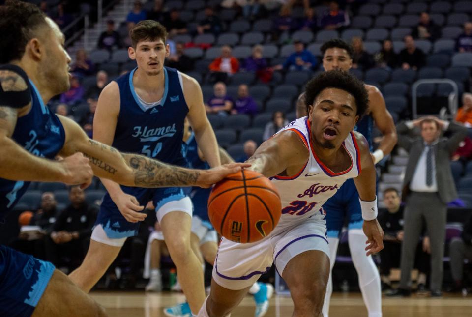 Evansville’s Kenny Strawbridge Jr. (20) and Illinois Chicago's Tre Anderson (4) reach for the ball as the University of Evansville Purple Aces play the University of Illinois at Chicago Flames at Ford Center in Evansville, Ind., Wednesday, Feb. 22, 2023. 