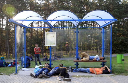 Migrants sleep at a bus stop after crossing into Hungary from the border with Serbia near Asotthalom, Hungary, August 30, 2015. REUTERS/Bernadett Szabo