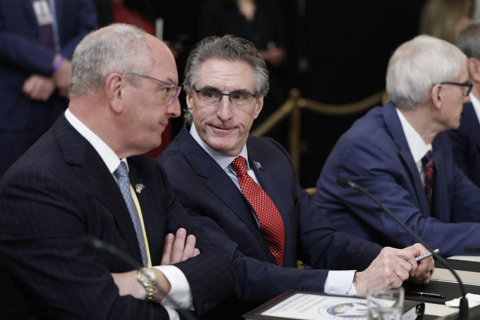 doug burgum leaning to his right as he listens to someone speaking