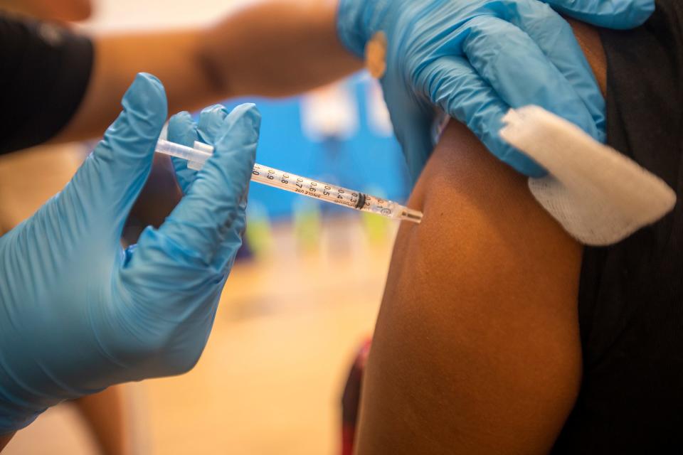 A person gets a COVID-19 vaccination shot.