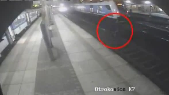 The two men continue to walk across the tracks as the speeding train hurtles towards them. Photo: LiveLeak