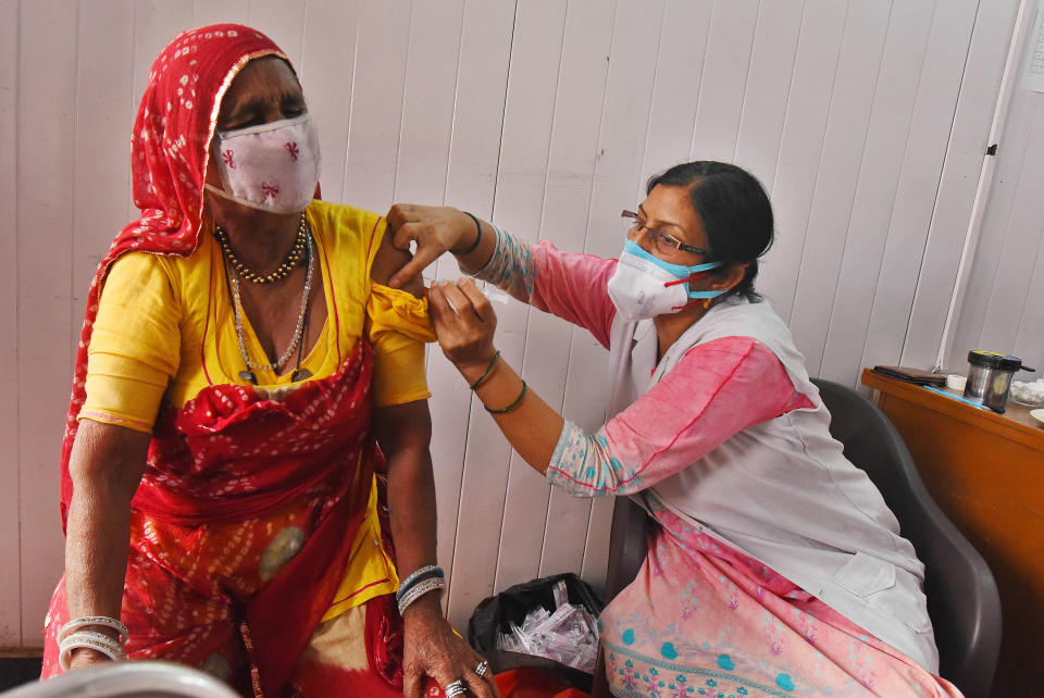 A resident of a street artists' transit camp is inoculated against COVID-19 in New Delhi. (Photo: Raj K Raj/Hindustan Times via Getty Images)