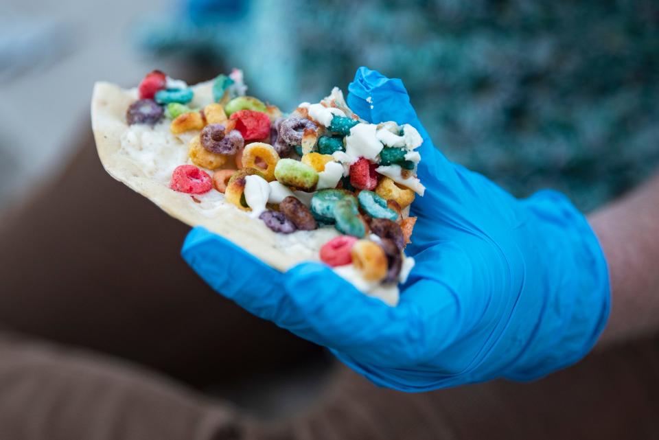 Former Des Moines Register reporter Robin Opsahl tries Fong's Pizza's Loopy Fruits pizza, made with sour cream, cream cheese sauce, mozzarella cheese, Fruit Loops, Greek yogurt, and condensed milk. The pizza was created at the now closed Fong's on Forest Avenue.