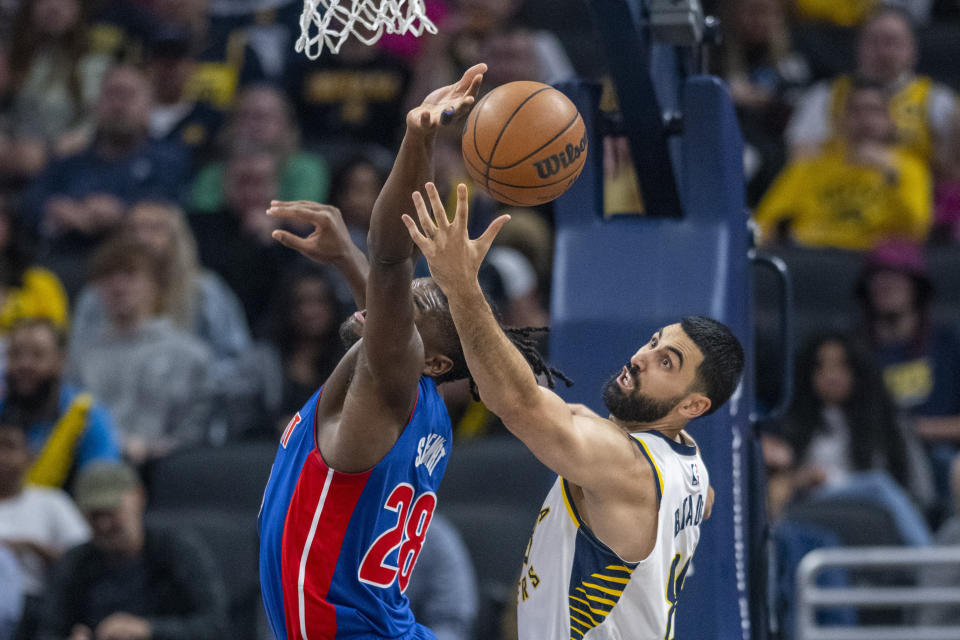 Detroit Pistons center Isaiah Stewart, left, and Indiana Pacers center Goga Bitadze reach for a rebound during the first half of an NBA basketball game in Indianapolis, Saturday, Oct. 22, 2022. (AP Photo/Doug McSchooler)