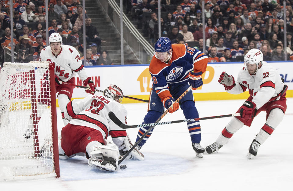 Carolina Hurricanes goalie Antti Raanta (32) makes a save on Edmonton Oilers' Zach Hyman (18) as Brett Pesce (22) trails during the second period of an NHL hockey game Wednesday, Dec. 6, 2023, in Edmonton, Alberta. (Jason Franson/The Canadian Press via AP)