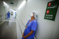 FILE - In this March 19, 2021 file photo, a health worker pauses in the ICU unit for COVID-19 patients at the Hospital das Clinicas in Porto Alegre, Brazil. As Brazil hurtles toward an official COVID-19 death toll of 500,000 — second-highest in the world — science is on trial inside the country and the truth is up for grabs. (AP Photo/Jefferson Bernardes, File)