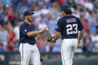 Mississippi starting pitcher Dylan DeLucia, left, hands the ball to relieving pitcher Josh Mallitz (23) in the eighth inning against Auburn during an NCAA College World Series baseball game Saturday, June 18, 2022, in Omaha, Neb. (AP Photo/John Peterson)