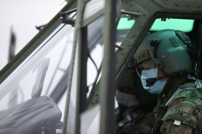 Un piloto del Ejército Nacional de Cclombia usa un tapabocas dentro de un helicóptero antes de iniciar un sobrevuelo en Bogotá