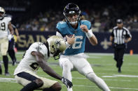 Jacksonville Jaguars quarterback Trevor Lawrence (16) tries to avoid a hit by New Orleans Saints cornerback Paulson Adebo in the first half of an NFL preseason football game in New Orleans, Monday, Aug. 23, 2021. (AP Photo/Derick Hingle)