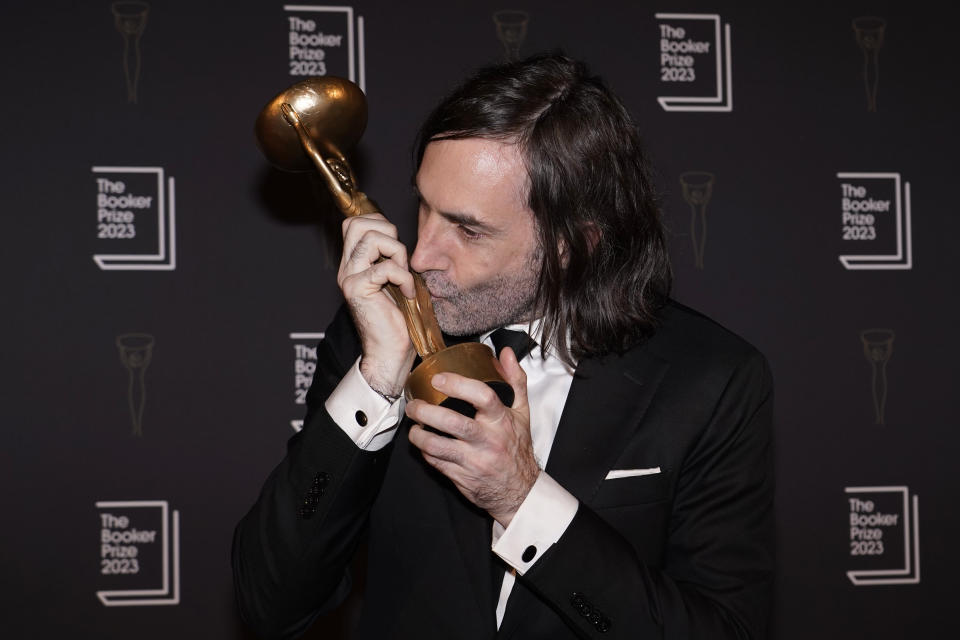 Paul Lynch, Winner of the 2023 Booker Prize poses for the media with his trophy following the presentation ceremony in London, Sunday, Nov. 26, 2023. The Booker Prize is awarded to the best sustained work of fiction written in English and published in the UK and Ireland, in the opinion of the judges. Lynch won with his book 'Prophet Song', a dystopian vision of Ireland in the grips of totalitarianism. (AP Photo/Alberto Pezzali)