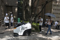 In this Aug. 20, 2019, photo, a chef looks as vendors test an autonomous sweeping robot that uses 5G technologies at the Huawei Campus in Shenzhen in Southern China's Guangdong province. Facing a ban on access to U.S. technology, Chinese telecom equipment maker Huawei is showing it increasingly can do without American components and compete with Western industry leaders in pioneering research. (AP Photo/Ng Han Guan)