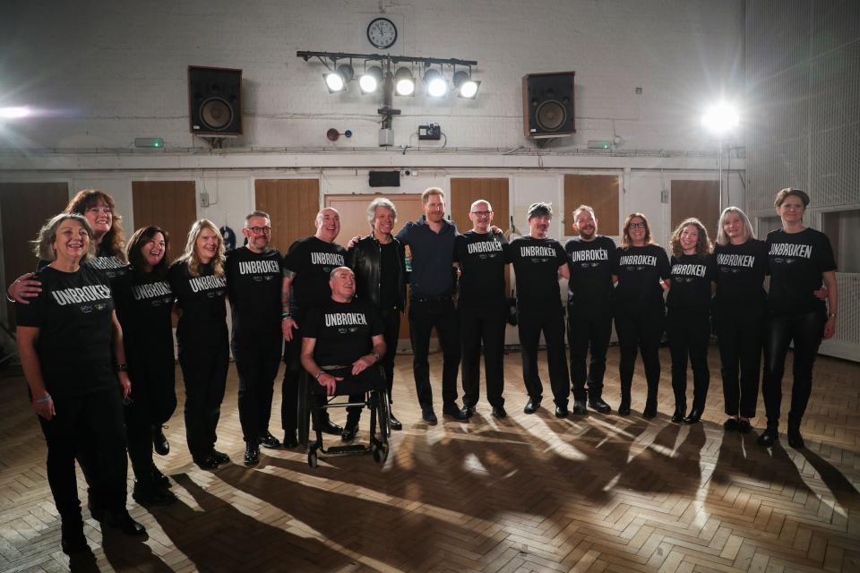 The two pose with members of the Invictus Games Choir.&nbsp; (Photo: HANNAH MCKAY via Getty Images)