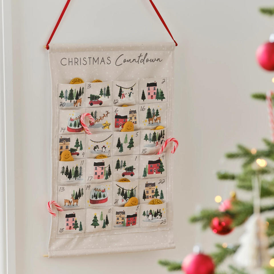 a Fill-Your-Own Advent Calendar hanging with candy canes in some pockets