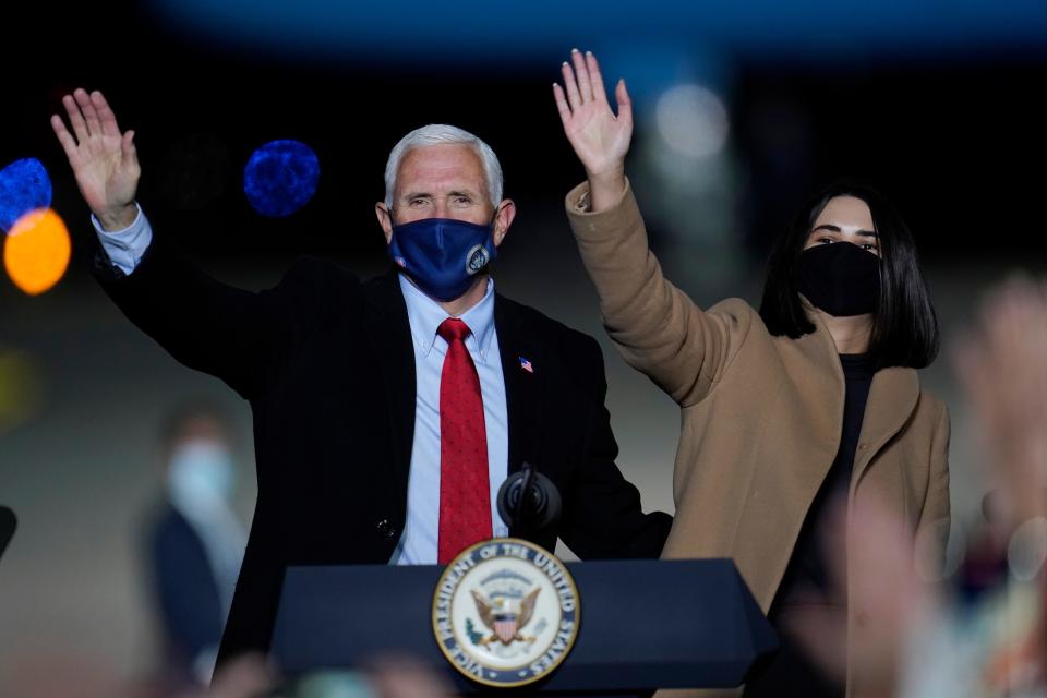 Vice President Mike Pence and his daughter Audrey acknowledge his supporters after speaking at a campaign event Wednesday in Flint, Michigan.