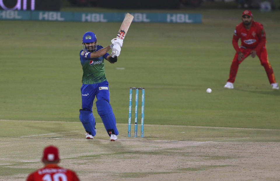 Multan Sultans' Mohammad Rizwan, center, plays a shot for boundary during a Pakistan Super League T20 cricket match between the Multan Sultans and Islamabad United at the National Stadium, in Karachi, Pakistan, Sunday, Feb. 21 2021. (AP Photo/Fareed Khan)