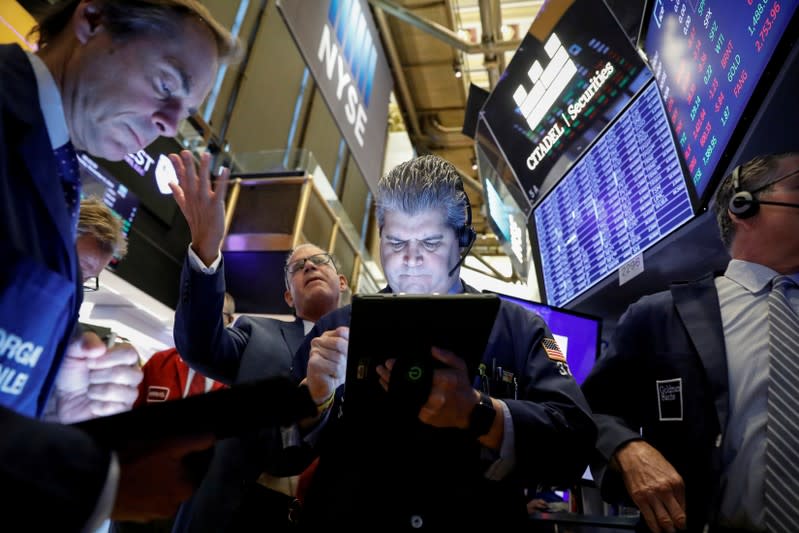 FILE PHOTO: Traders work on the floor at the NYSE in New York