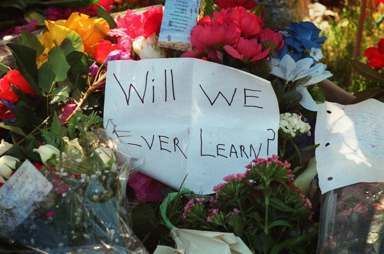 A message sits among the flowers in the memorial in front of Springfield's Thurston High School in the days following the mass shooting in 1998.