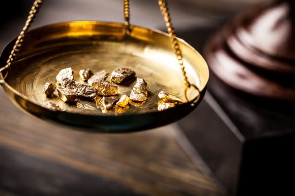 Tiny fragments of gold sitting on an old-fashioned scale.