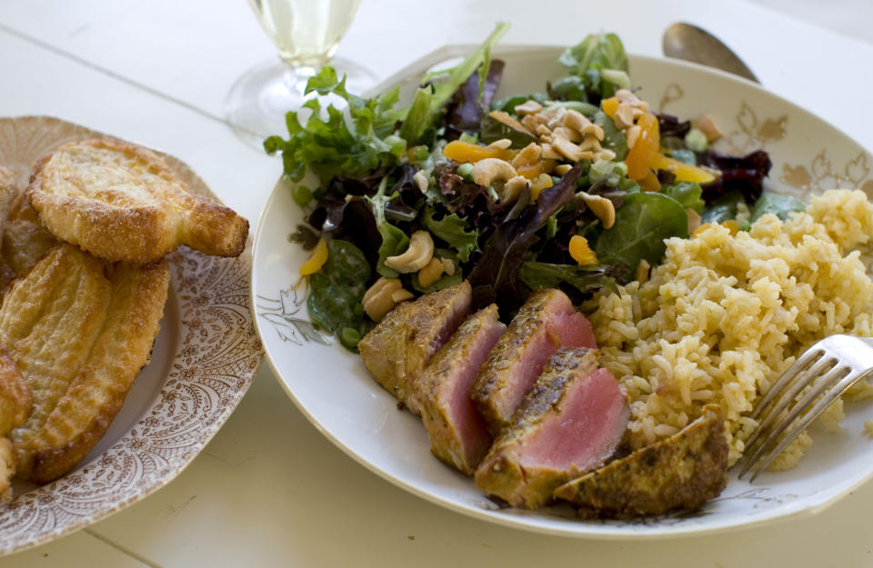 This Nov. 18, 2013 photo shows coconut cashew salad with apricots, seared curry rubbed tuna with mango tahini rice, and tangerine twirls in Concord, N.H. It's a mash-up that draws on the flavors of the Caribbean, Southeast Asia and Europe. (AP Photo/Matthew Mead)