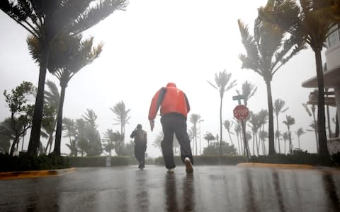 People walk along a street in South Beach as Hurricane Irma arrives at south Florida, in Miami Beach - Credit:  CARLOS BARRIA