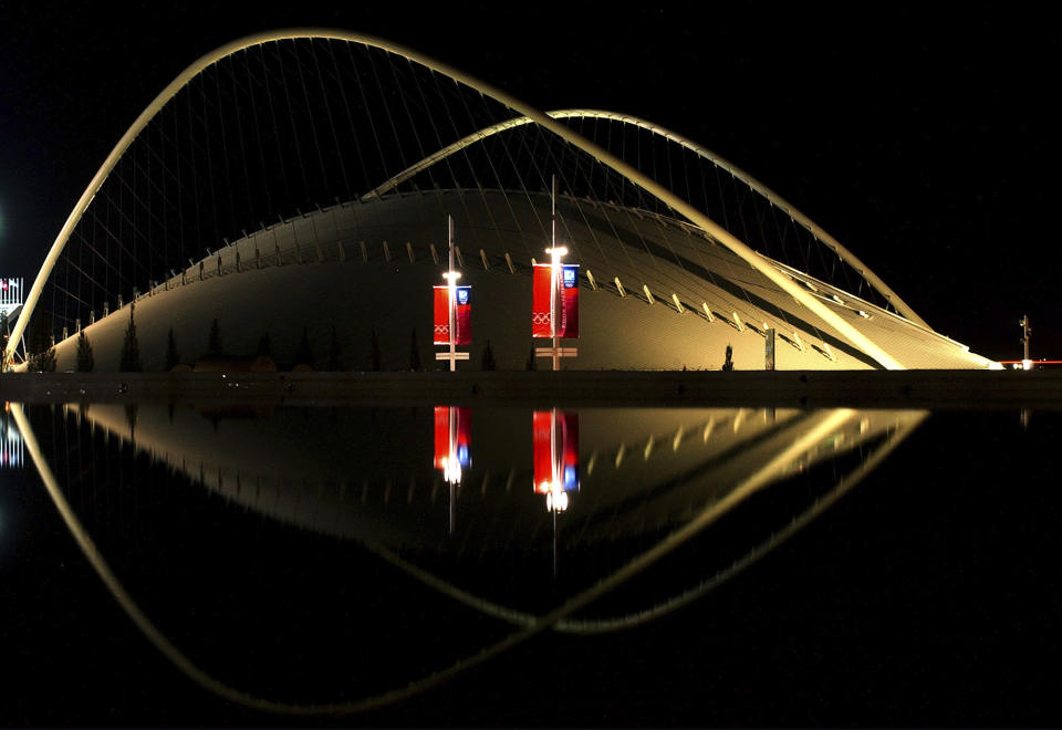 FILE - The velodrome is reflected in a pool of water at Athens' main Olympic complex, Greece, Tuesday, Aug. 3, 2004. Government officials say Monday, Oct. 2, 2023 a new inspection has been ordered at a stadium that hosted the Athens Olympics in 2004 after rust was found along the iconic arched roof, forcing the site to close. The arched roof structures were designed by renowned Spanish architect Santiago Calatrava for the 2004 Athens Olympics. (AP Photo/Petros Giannakouris, File)