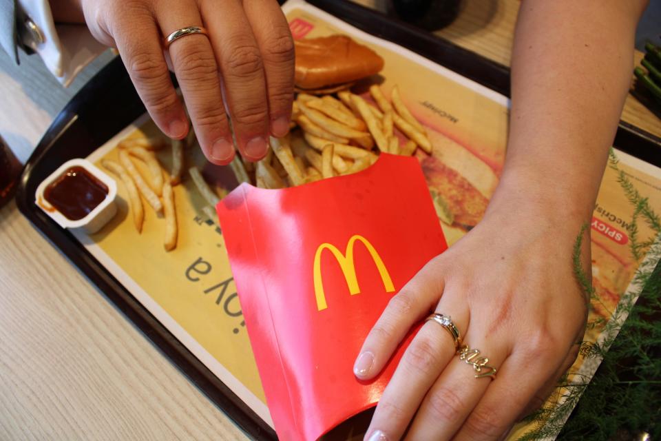 Mike and Kathi Haller, newlyweds from Munich, Germany, show off rings as they eat fries from local Michigan McDonald's
